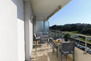 d'une terrasse avec des tables et des chaises sur un balcon. dans l'établissement Bright T2 "Golf Panorama" air-conditioned parking golf view, à Biot