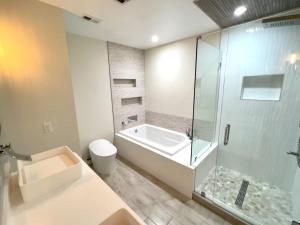 ein Bad mit einer Badewanne, einer Dusche und einem WC in der Unterkunft Escape to Lake Talquin High End Modern Style Open Design in Tallahassee
