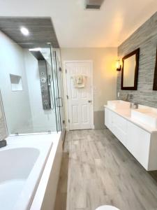 ein Bad mit einer Badewanne, 2 Waschbecken und einer Dusche in der Unterkunft Escape to Lake Talquin High End Modern Style Open Design in Tallahassee