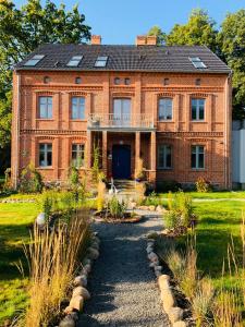 una vieja casa de ladrillo con un camino delante de ella en Uroczysko Gryżyna, en Gryżyna