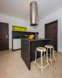 a kitchen with a counter and two stools in it at Studio Apartment Stela in Vrboska