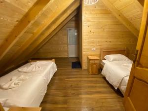 two beds in a room with a attic at Adenisi guesthouse in Tropojë