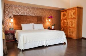 een slaapkamer met een groot wit bed in een kamer bij Uzhupud Garden Hotel & Lodge in Paute
