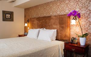 een hotelkamer met een bed en een telefoon bij Uzhupud Garden Hotel & Lodge in Paute