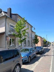 Une rangée de voitures garées sur le côté d'une rue dans l'établissement Centro apartamentai, à Kalvarija