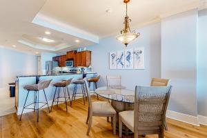 a kitchen and dining room with a table and chairs at Holiday Isle 715 in Dauphin Island