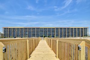 a wooden boardwalk leading to a large building at Holiday Isle 715 in Dauphin Island