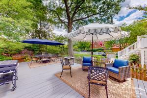 une terrasse avec des chaises, des tables et un parasol dans l'établissement Seas The Bay, à Annapolis