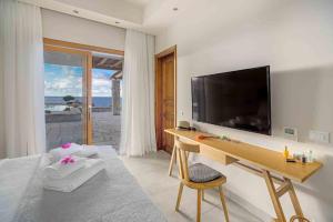 a bedroom with a desk and a television on a wall at Ιδιωτικό στυλ και ατμόσφαιρα in Xerokampos