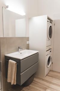 een badkamer met wastafel en wasmachine bij Studio-Appartment - Hotel Lux in Merano