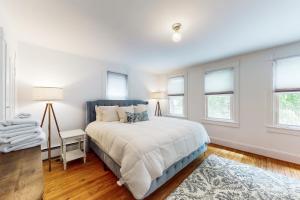 a white bedroom with a large bed and windows at Seas The Bay in Annapolis