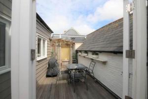 a balcony with a table and chairs on a house at Apartment with Roof Terrace - Centre of Yarmouth in Yarmouth