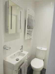 a white bathroom with a toilet and a sink at Apartment with Roof Terrace - Centre of Yarmouth in Yarmouth +16 photos