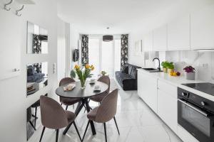 a kitchen and dining room with a table and chairs at Sleepy3city Plac Unii in Gdynia