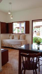 um quarto com uma cama e uma mesa com uma cadeira em Pousada Vila Caju em São Miguel do Gostoso