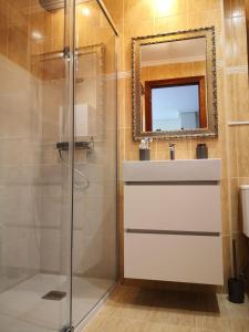 ein Bad mit einer Dusche, einem Waschbecken und einem Spiegel in der Unterkunft Apartamento Vistas Rovacias in Comillas