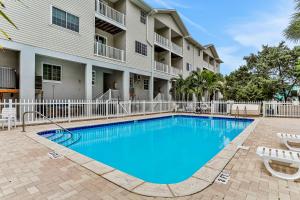 a swimming pool in front of a building with two lounge chairs at Madeira Beach Manor in St Pete Beach