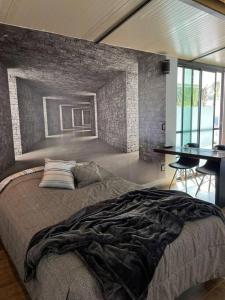 a bedroom with a large bed with a brick wall at Studio C Minerva zona residencial 1er piso in Guadalajara
