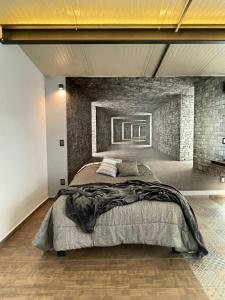 a bedroom with a large bed and a brick wall at Studio C Minerva zona residencial 1er piso in Guadalajara