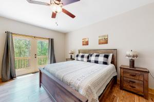 a bedroom with a bed and a ceiling fan at Woodstone Trail Tranquility in Ellijay