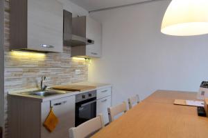 a kitchen with a sink and a table with chairs at Mountain Studio 109A in Breuil-Cervinia