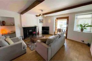 a living room with couches and a fireplace at Brook Cottage in the heart of Yorkshire in Baildon