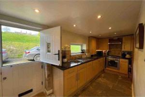 a kitchen with a car parked outside a window at Brook Cottage in the heart of Yorkshire in Baildon