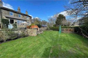 a yard of a house with a green lawn at Brook Cottage in the heart of Yorkshire in Baildon