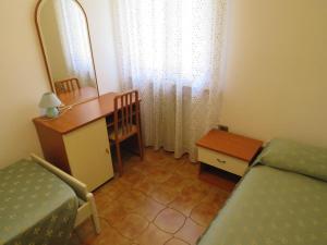 een slaapkamer met een bed, een bureau en een spiegel bij Appartamento Oberdan in Milano Marittima