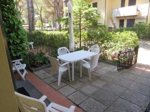 un tavolo bianco e sedie su un patio di Appartamento Oberdan a Milano Marittima