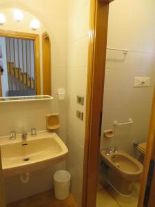a bathroom with a sink and a toilet and a mirror at Appartamento Oberdan in Milano Marittima