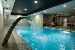 a pool with a water fountain in a building at Volga Hotel Baku in Baku