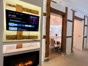 sala de estar con chimenea y TV en la pared en Luxury10 Loft plaza mayor, en Madrid