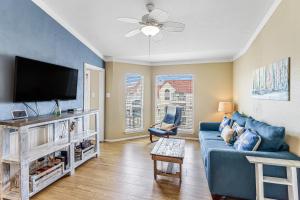 ein Wohnzimmer mit einem blauen Sofa und einem Flachbild-TV in der Unterkunft Casa Del Sol in Padre Island