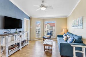 a living room with a blue couch and a flat screen tv at Casa Del Sol in Padre Island