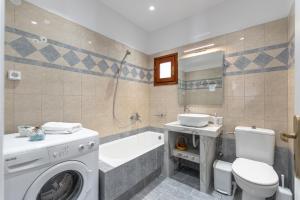a bathroom with a washing machine and a sink and a toilet at Amaranto Naxos in Naxos Chora