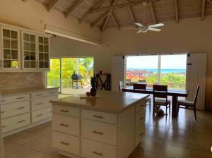 cocina con mesa y comedor en Villa Belvedere - 5 minutes walk to the Beach, en Dickenson Bay