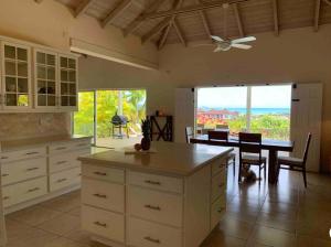 a kitchen with a table and a dining room at Villa Belvedere - 5 minutes walk to the Beach in Dickenson Bay