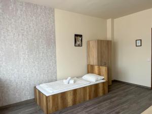 1 dormitorio con 1 cama y armario de madera en Wolf Panzió, en Sárvár