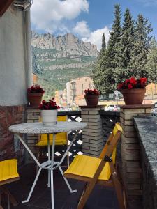 a table and chairs on a balcony with a mountain at Casa iaia in Monistrol