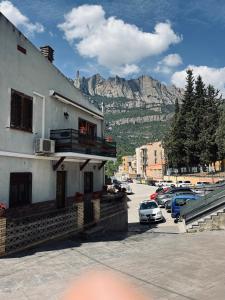 un edificio en un estacionamiento con montañas en el fondo en Casa iaia, en Monistrol