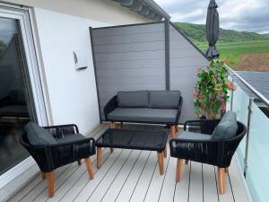 patio z 2 krzesłami i kanapą na tarasie w obiekcie 2 Zimmer im Loft style über 2 Etagen w mieście Kelheim