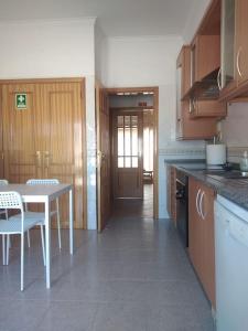 a kitchen with a table and a table and chairs at Navigation House in Sesimbra