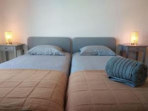two beds sitting next to each other in a room at Navigation House in Sesimbra
