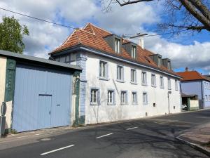 a white building with a garage on a street at Vintner Suites in Neustadt an der Weinstraße