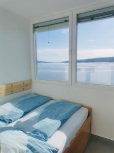due letti in una stanza con due finestre di SUZANA Beautiful balcony sea view 1 a Senj