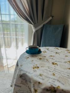 eine Tasse auf einem Tisch neben einem Fenster in der Unterkunft Tamerlan in Chmelnyzkyj