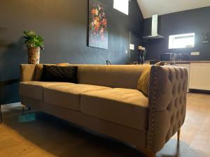 a brown couch in a living room with a table at Gîte "Le Loft" in Chamblet