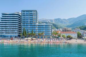 a group of people on a beach in the water at Sunraf Luxe Apartments in Rafailovici