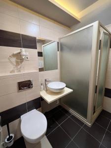 een badkamer met een toilet, een wastafel en een douche bij Wolf Panzió in Sárvár